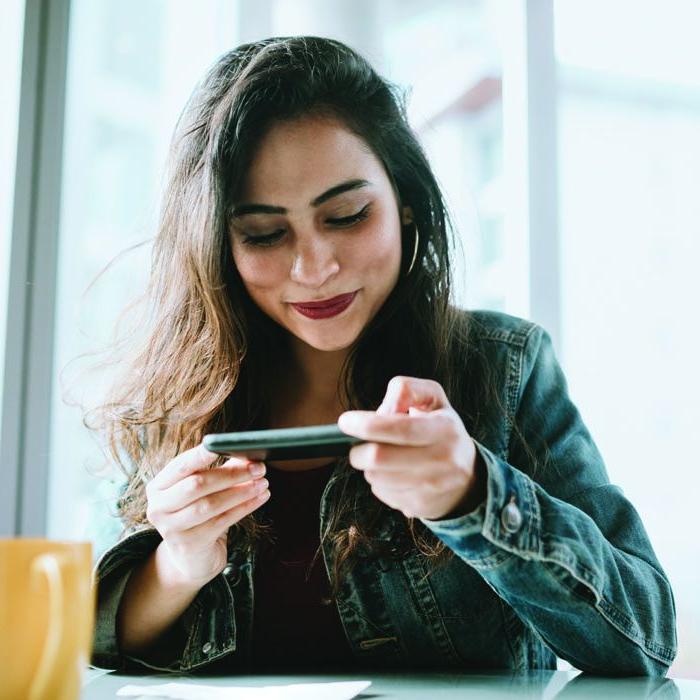 A woman snaps a photo of a check with the Patelco mobile banking app.